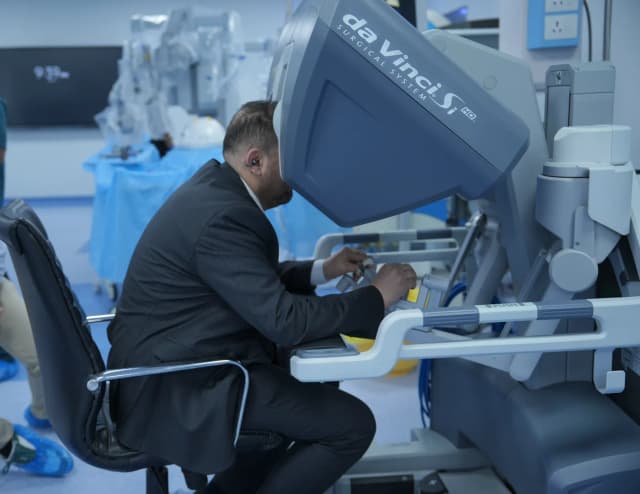 Dr. Mohammad Al-Zaitawi at the da Vinci surgical robot console, experienced in robotic gastric bypass in Jordan
