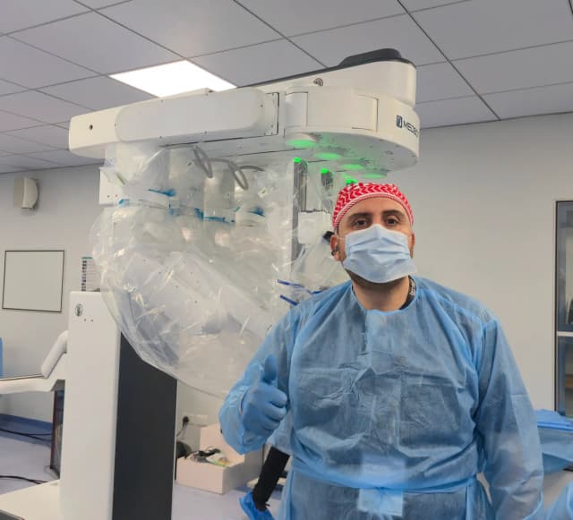 Dr. Mohammad Al-Zaitawi next to the MedBot surgical robot he uses for robotic sleeve gastrectomy and robotic gastric bypass in Jordan