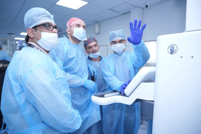Dr. Mohammad Al-Zaitawi with a team of surgeons around the robotic console during advanced robotic bariatric surgery training